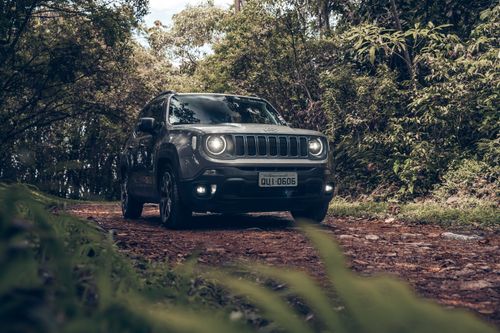 Free A rugged SUV navigates a dirt road surrounded by lush green trees in São Paulo, Brazil. Stock Photo