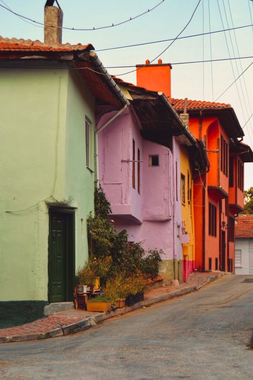 Free A serene street lined with colorful houses painted in hues of green, purple, orange, and more. Stock Photo