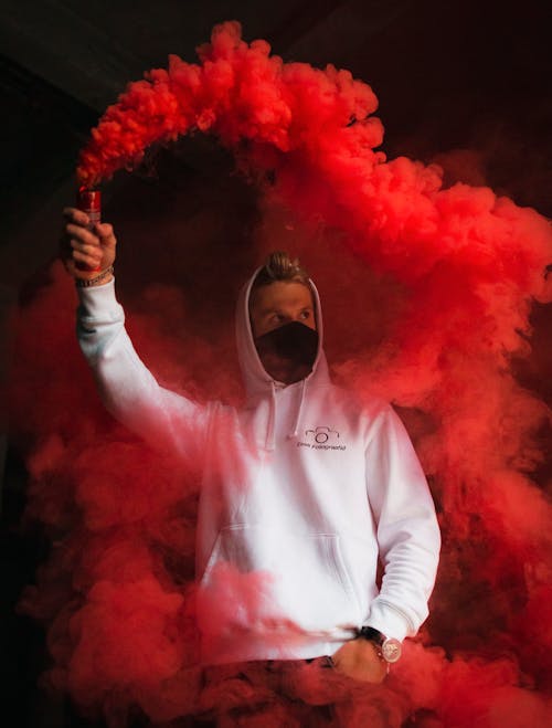 Photo of a Man Holding a Smoke Bomb