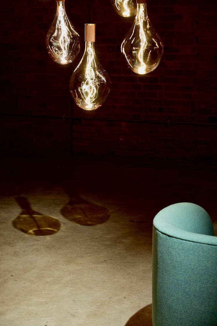 Four Hanging Light Bulbs Beside Chair