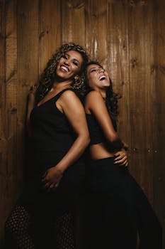 两个女人在室内对着质朴的木墙欢笑，表达着幸福和友谊