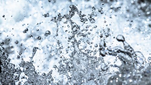 Free High-speed photo capturing water droplets mid-air in vivid detail. Stock Photo