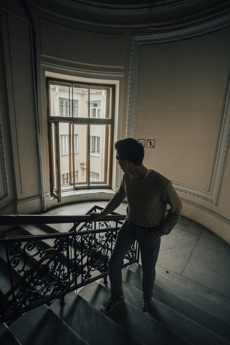 Man Walking Stairs In Old House