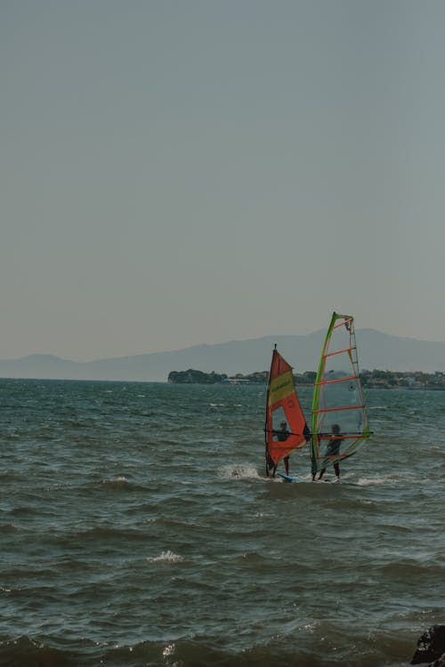 Two People Windsurfing on the Sea