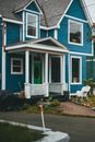 White Plastic Armchair Beside Blue and White Wooden House