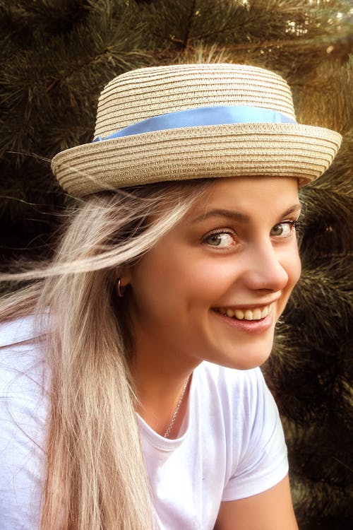 Close-Up Shot of a Woman in White Shirt Wearing Brown Fedora Hat