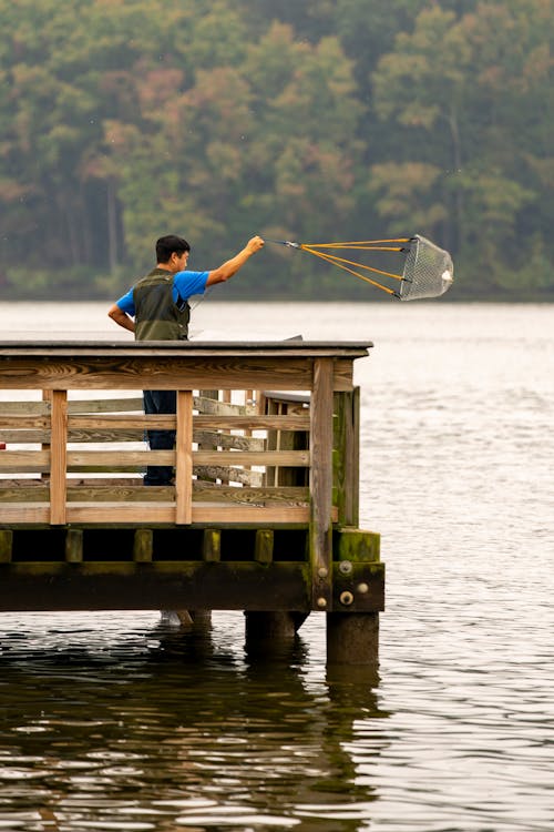Photo of a Man Fishing on a Dock