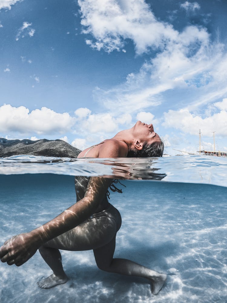 Young Woman Standing In A Clear Transparent Sea Water