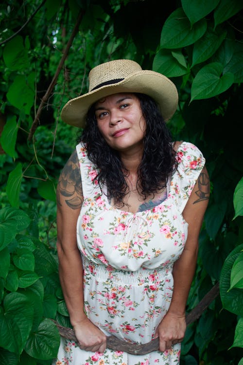 A Tattooed Woman Wearing a Floral Dress and a Hat