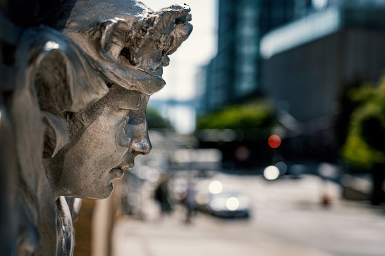 Statue Head On Modern City Blur Background