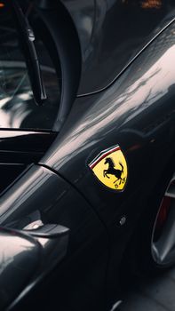 Sleek gray Ferrari emblem displayed on a luxury car in Toronto's urban setting.