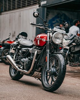 Close-up of a red motorcycle parked on a city street with license plate visible.