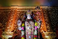 A vibrant statue of Goddess Durga adorned with flowers and gold in a Mumbai temple, embodying Hindu spirituality.
