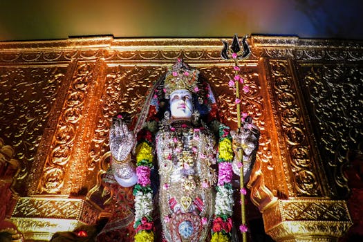 A vibrant statue of Goddess Durga adorned with flowers and gold in a Mumbai temple, embodying Hindu spirituality.