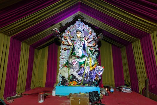 Colorful statue of Goddess Durga during a vibrant Indian festival indoors.