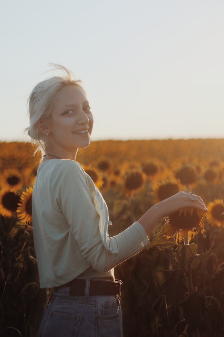 Smiling Woman In A Field On Sunflowers