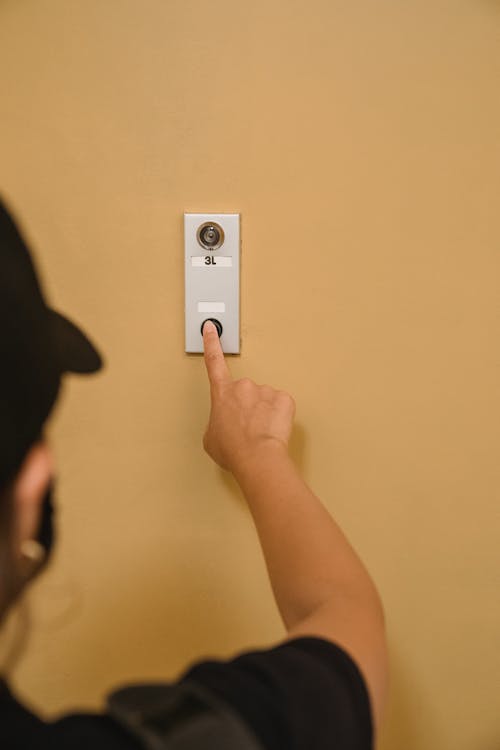A Person Pressing a Doorbell