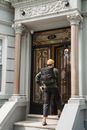 A Man with a Backpack Approaching the Front Door of the House
