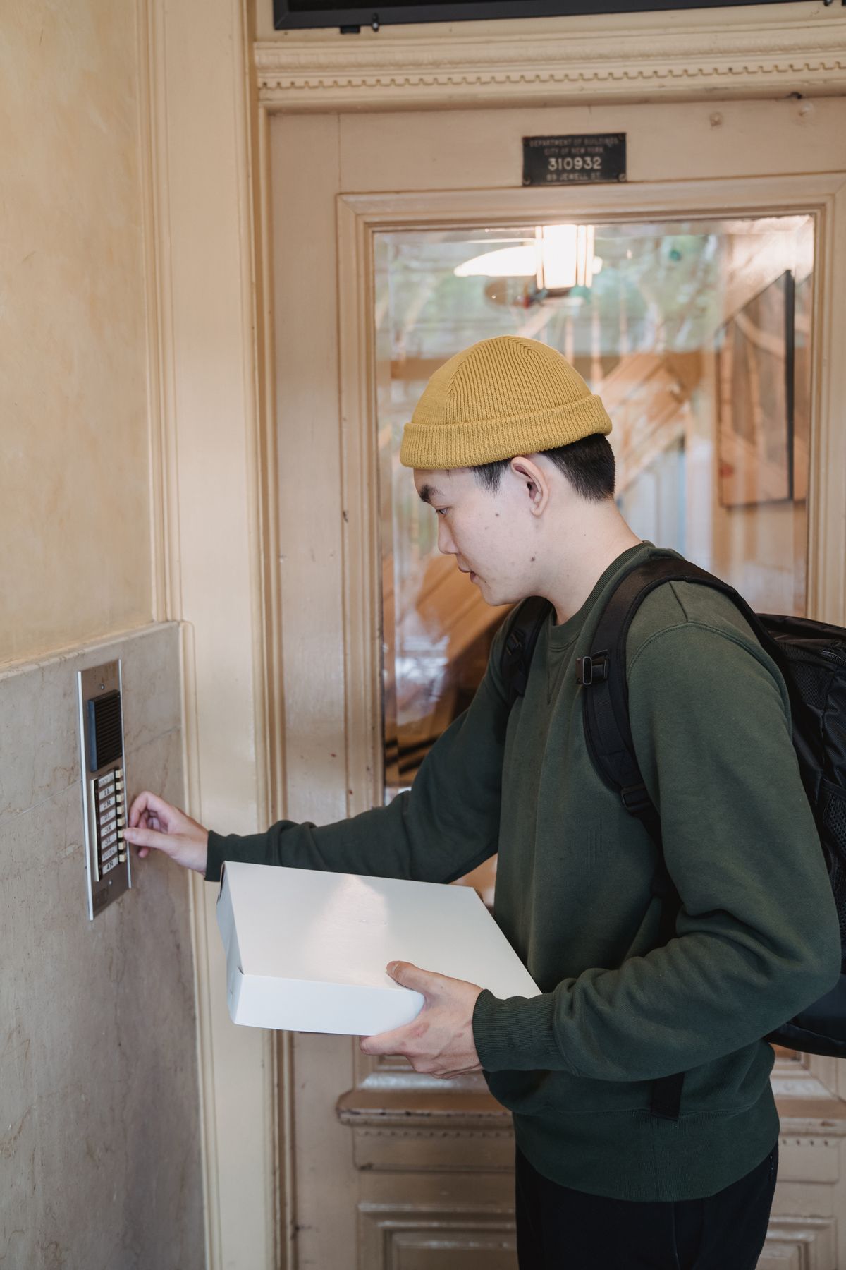 Delivery courier bringing medical equipment to an apartment door in Malaysia