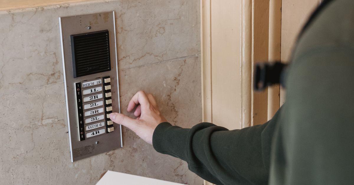Pressing Intercom A Courier Pressing an Intercom Doorbell · Free Stock Photo
