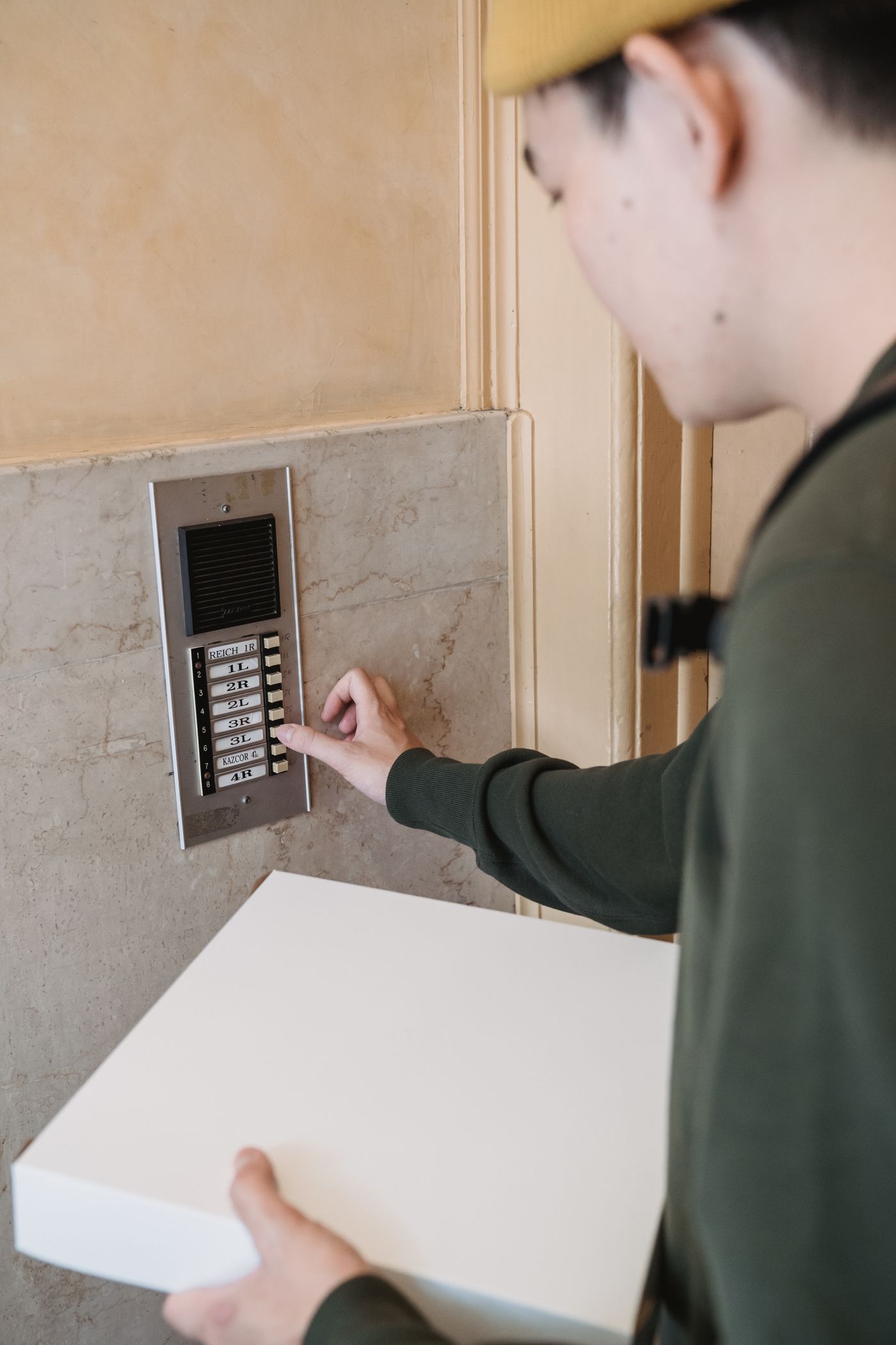 Apartman girişinde gerçek interkom diafon paneline basan ziyaretçi