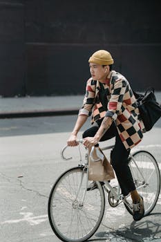 Asian courier riding a bicycle on city streets, showcasing urban delivery lifestyle.