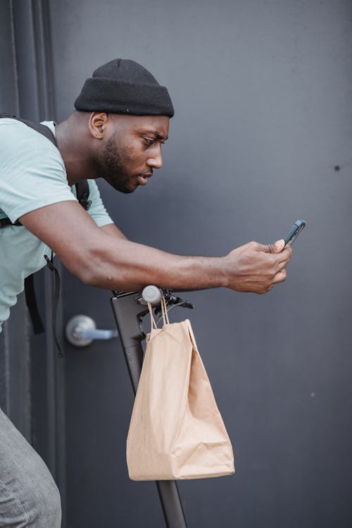 Man in White T-shirt Holding Smartphone