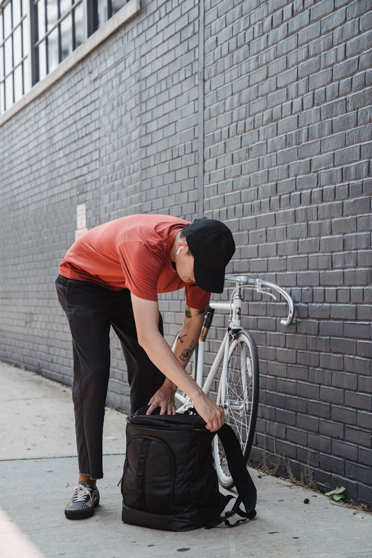 A Man Opening His Backpack