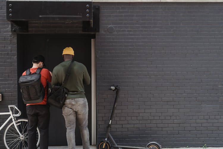 Couriers In Front Of A Brick Walled Building