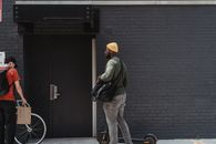 Couriers in Front of a Brick Walled Building