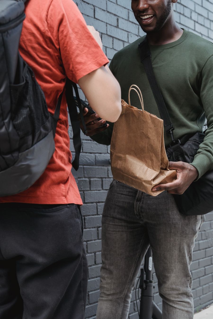 Un livreur remet un sac de commande à son client