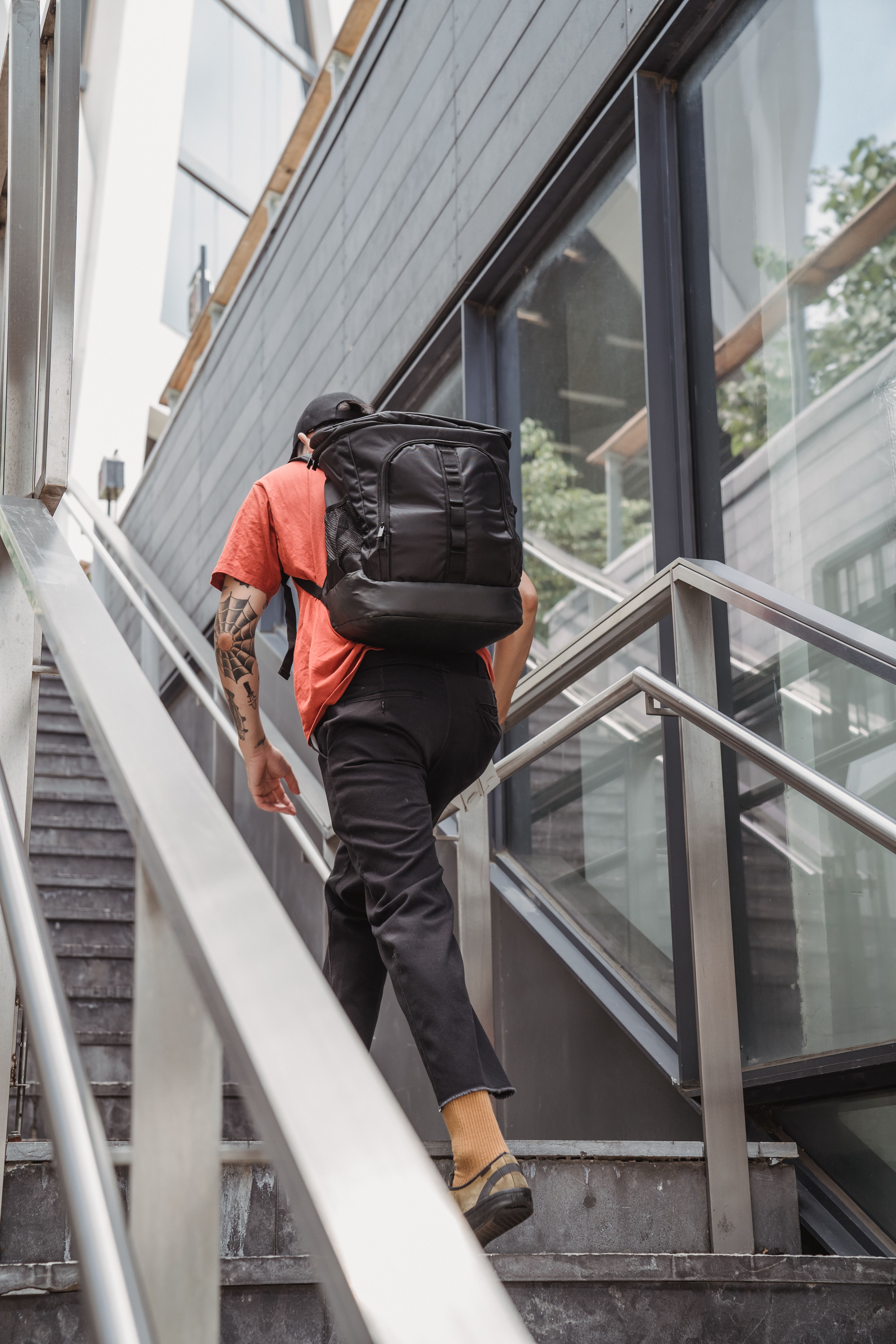 Delivery Man with Backpack Ascending Stairs · Free Stock Photo