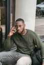 Man in Green Long Sleeve Shirt Sitting by the Window