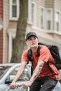 Man in Red and Black Stripe Polo Shirt Wearing Black Cap Sitting on Black and White