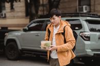 Man in Brown Coat Holding White Ceramic Bowl