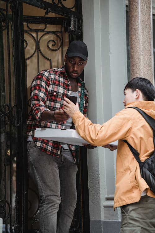 Man Delivering a Pizza to a Client