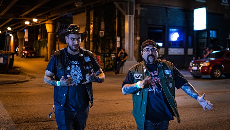 Men In Punk Outfits Walking Down Street At Night