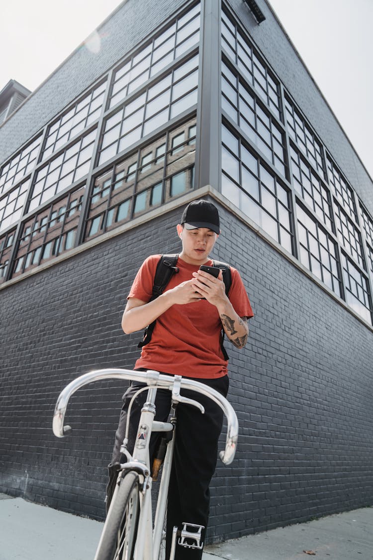 A Man On A Bicycle Using A Smart Phone