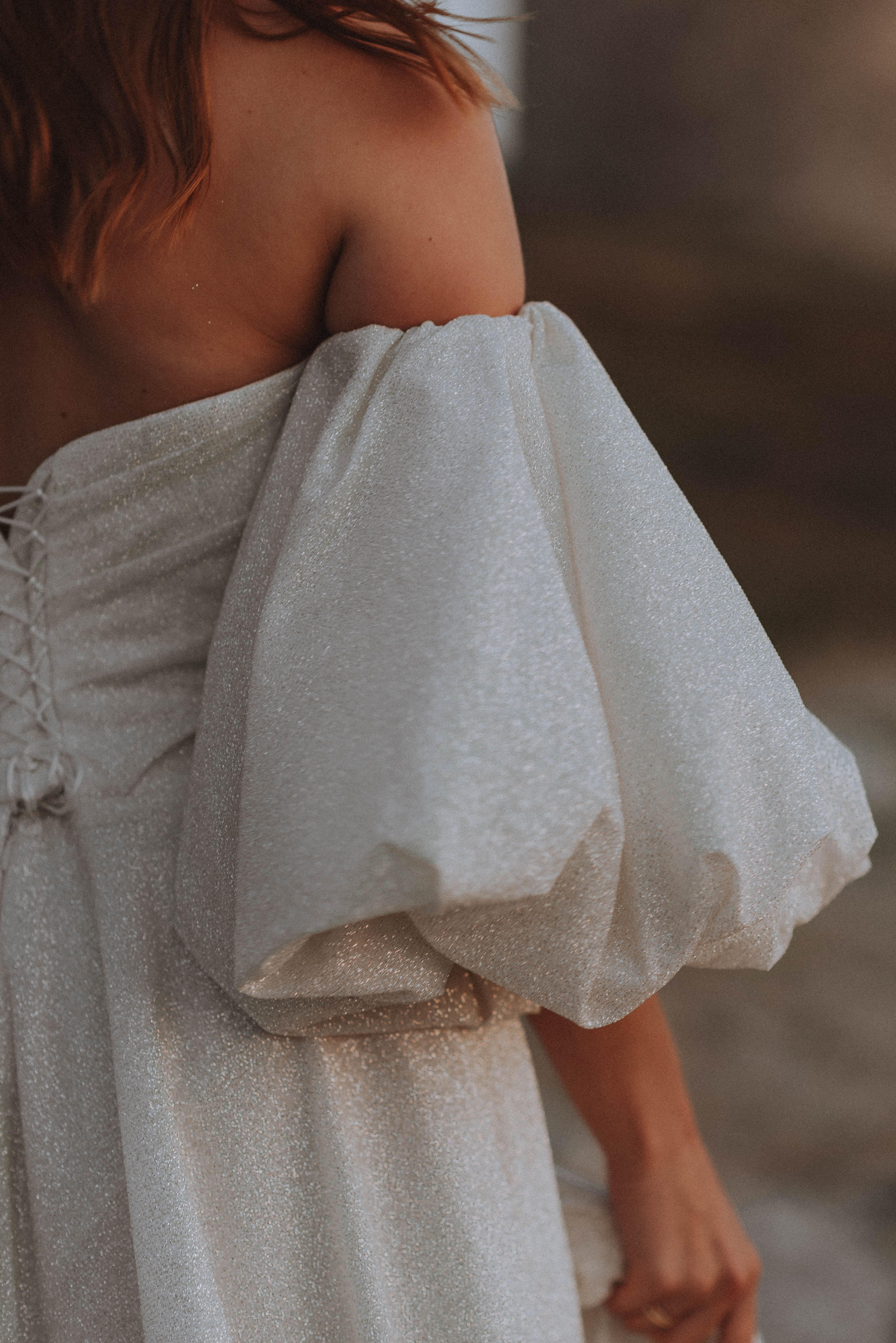 Stylish off-shoulder dress portrait capturing elegance and fashion in soft light.