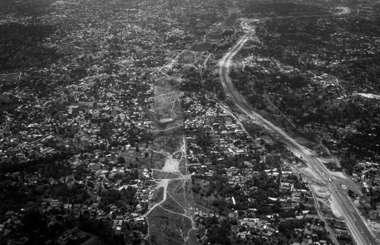 A dramatic aerial view of a Tanzanian city in striking black-and-white tones.