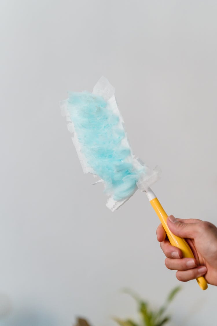 Person Holding Yellow Handle Swiffer