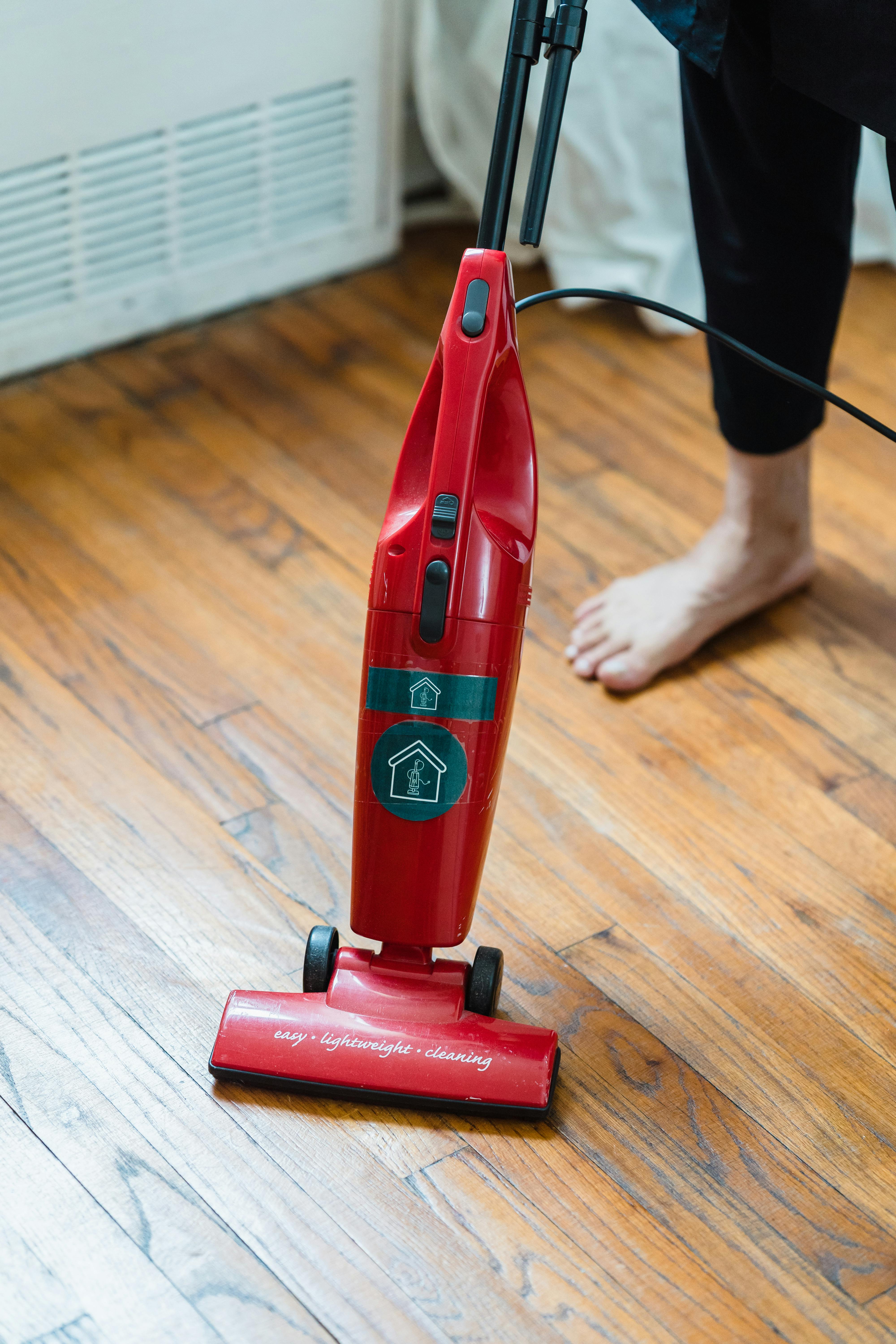 a red vacuum cleaner on a wooden floor