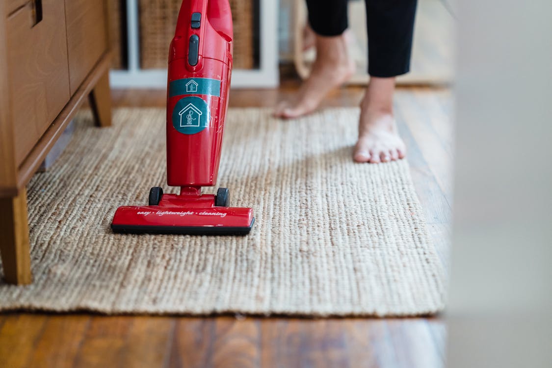 Free A Person Vacuuming a Carpet Stock Photo