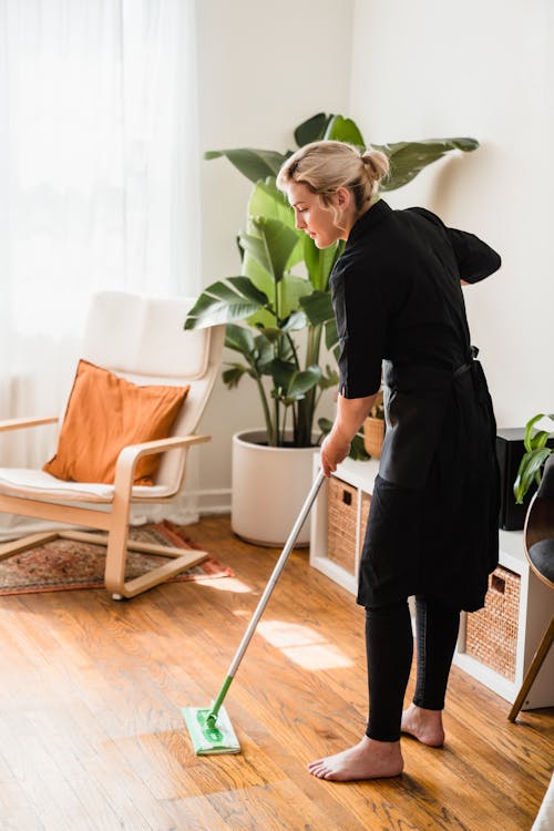 Free A Woman Sweeping a Floor Stock Photo