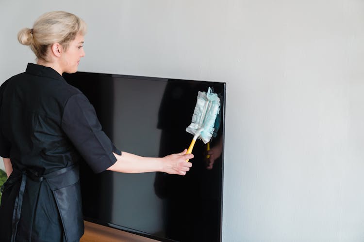 Woman Dusting The Television