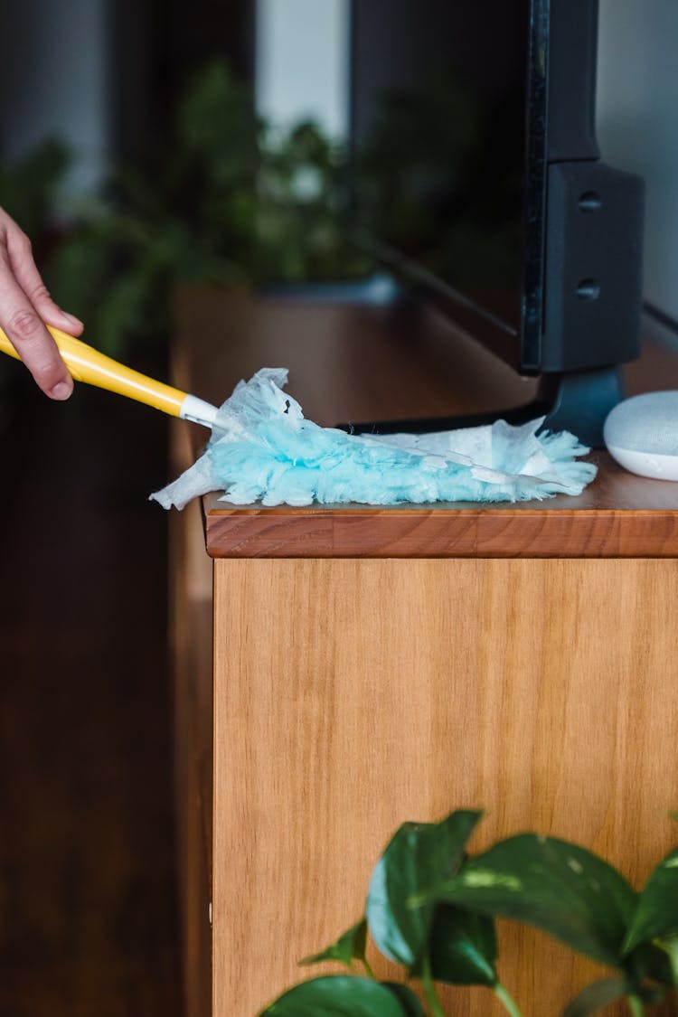 A Person Cleaning A Wooden Surface