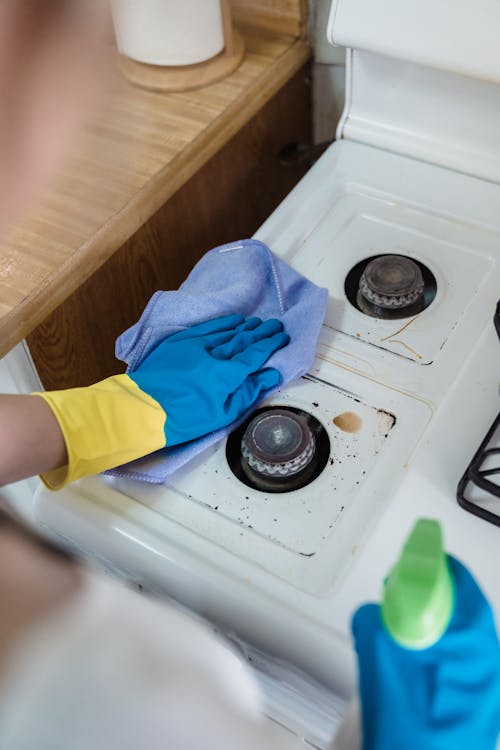 Free A Person Cleaning a Gas Stove Stock Photo