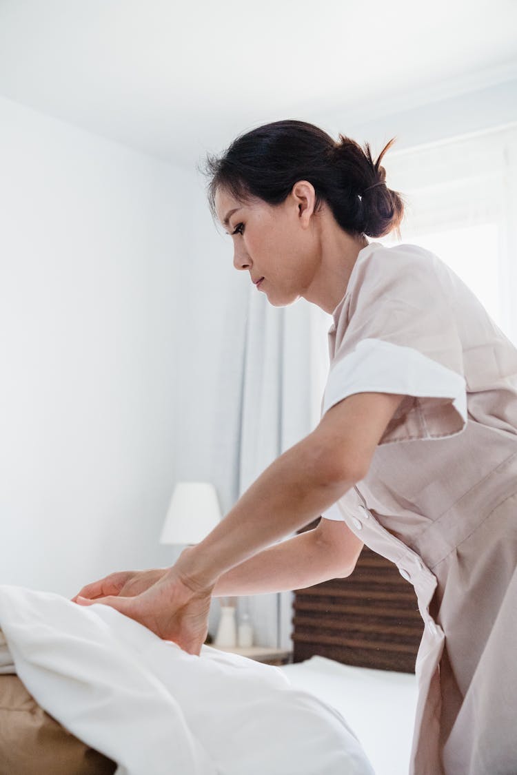 Housekeeper Cleaning The Bed