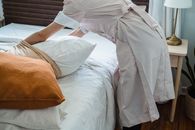 A Housekeeper Putting a Pillowcase on a Pillow