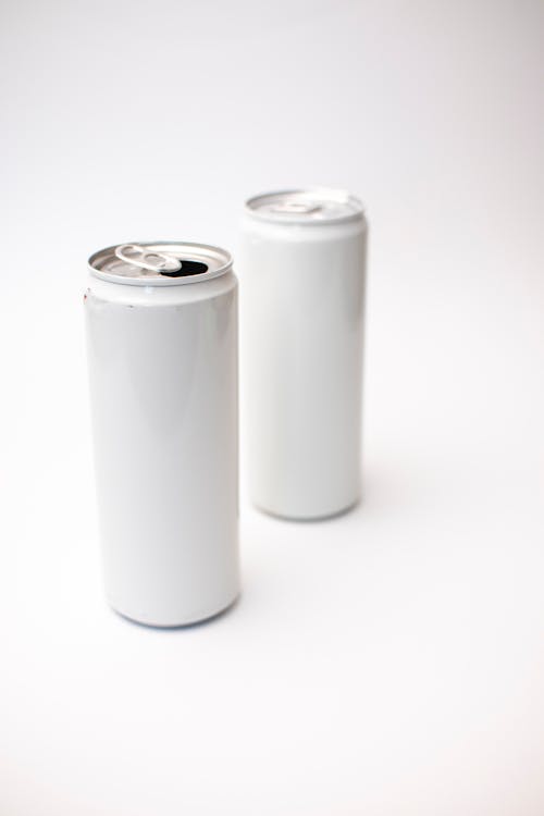 Close-Up Shot of Two White Cans on White Surface